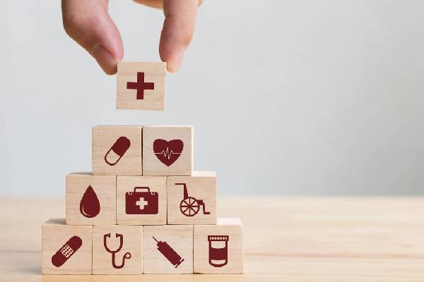 A person is stacking blocks with medical symbols.